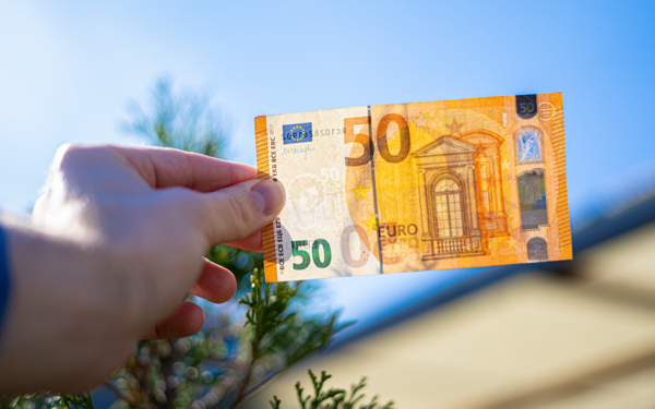 Een eurobiljet tegen het licht houden om te kijken of die echt of vals is