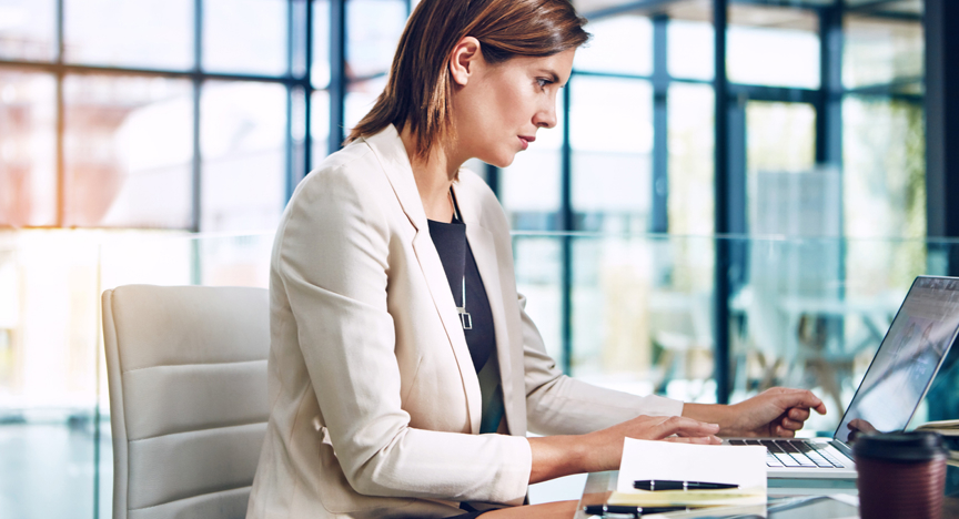 Vrouw achter laptop in kantoor omgeving