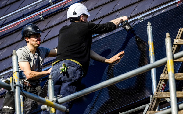 Montage van zonnepanelen in een nieuwbouwwijk.