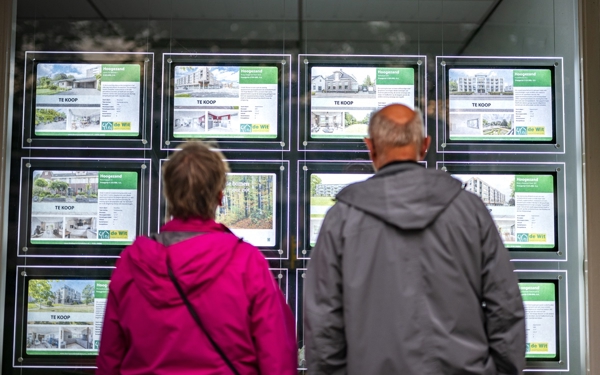 Echtpaar kijkt naar ruit tekoop woningen hypotheekverstrekker