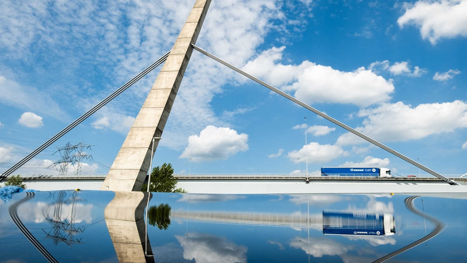 Vrachtwagen rijdt over de Brug van de A1 over het Amsterdam-Rijnkanaal. Weerspiegeling in water