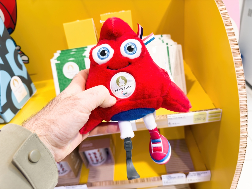 Een mannenhand die de Phryges Caps vasthoudt, de mascottes van de Olympische Spelen van 2024 in Parijs.