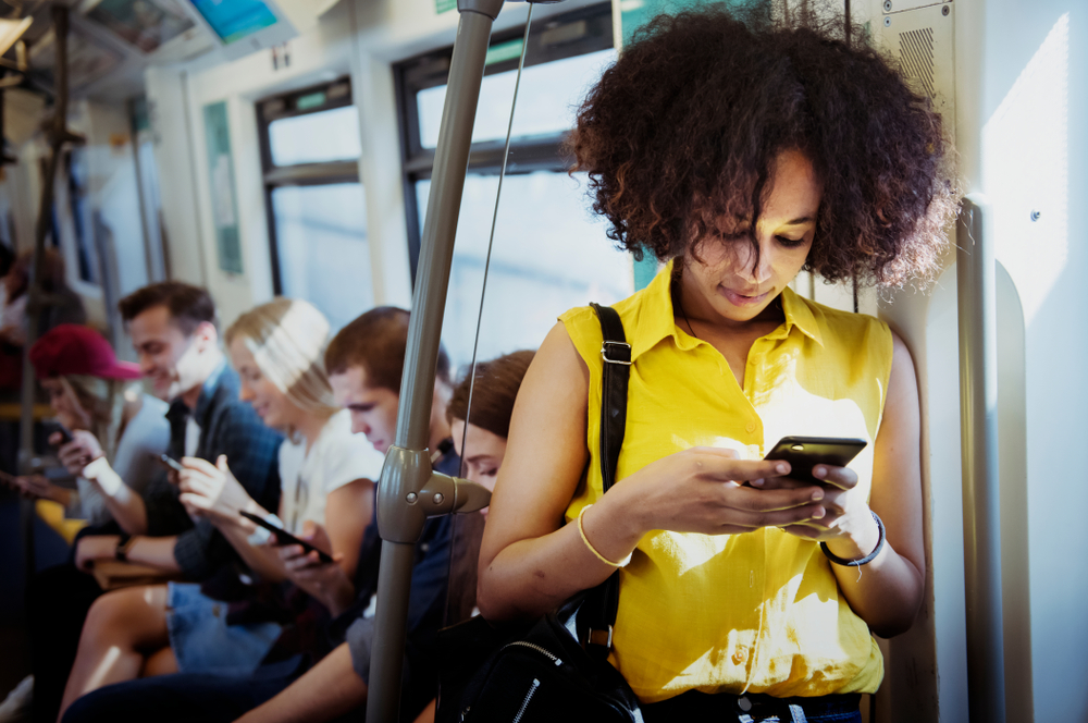 Jonge vrouw met smartphone in metro