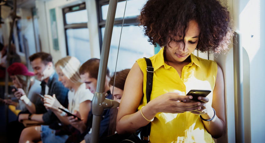 Jonge vrouw met smartphone in metro