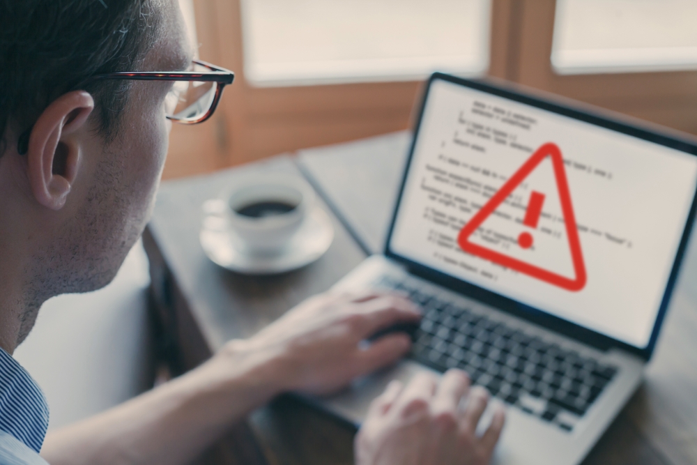 Cybersecurity allert op laptop van man 