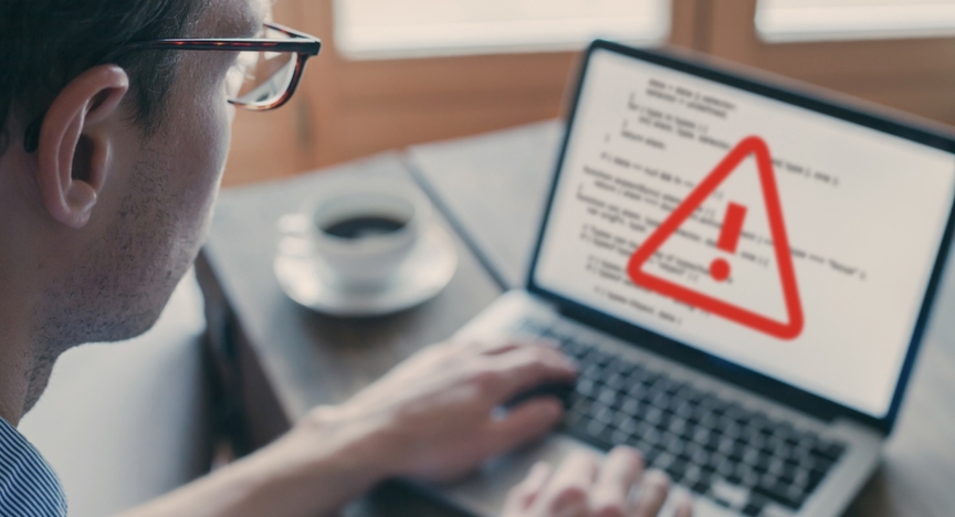 Cybersecurity allert op laptop van man 