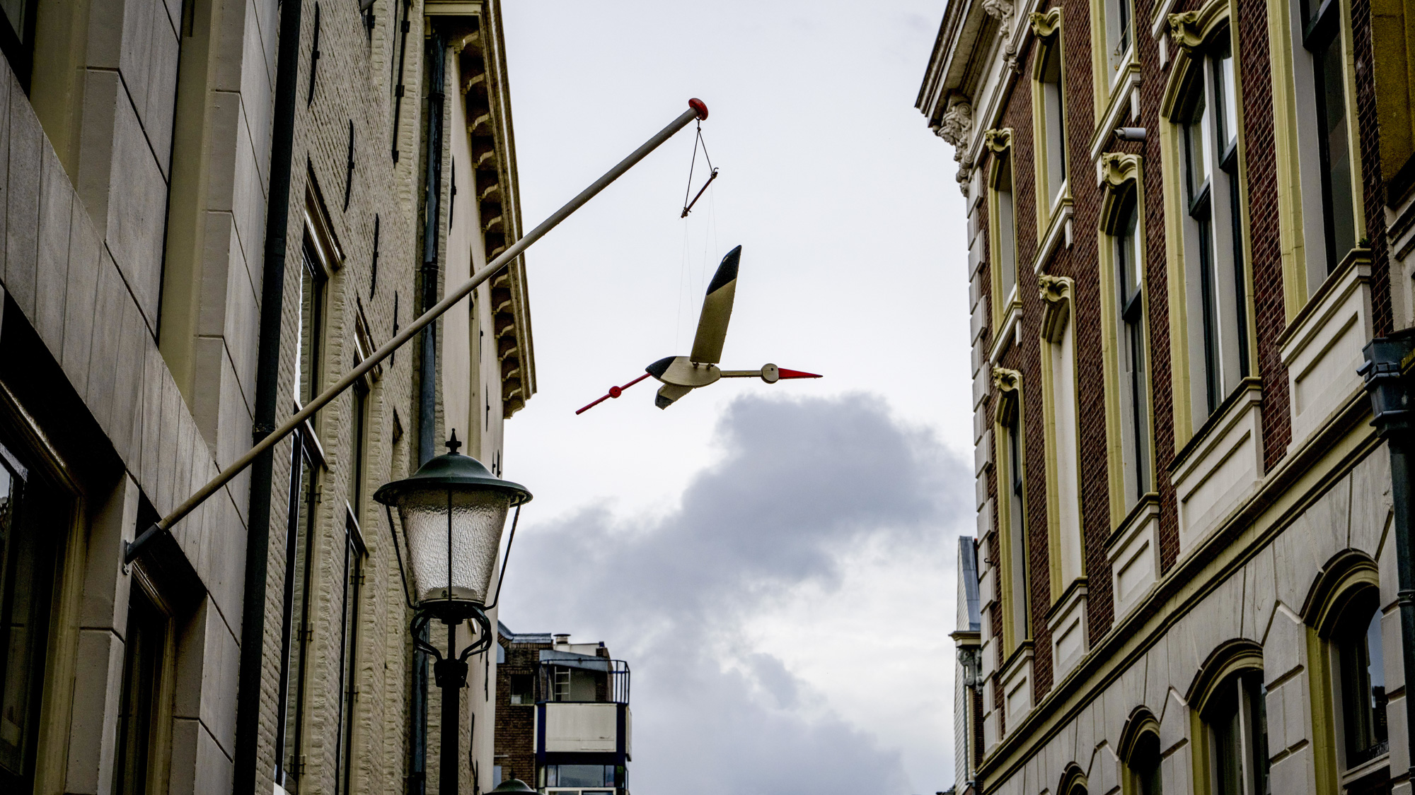 Een ooievaar hangt voor het huis waar een kindje is geboren.