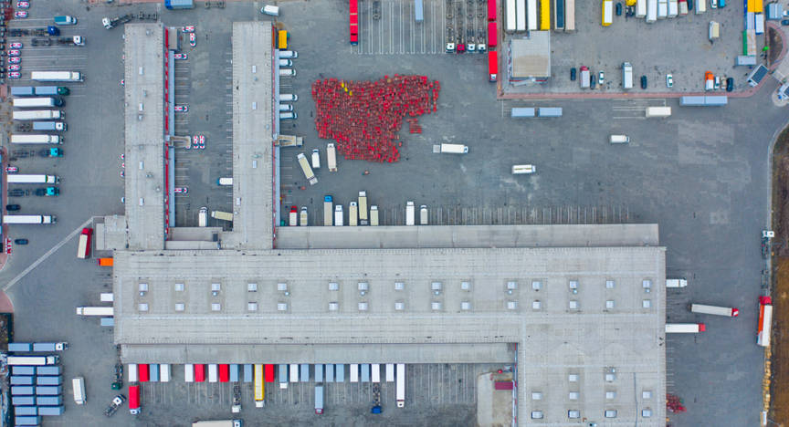 Luchtfoto van groot logistieke park met vrachtwagens die klaar staan voor het laden/lossen van goederen