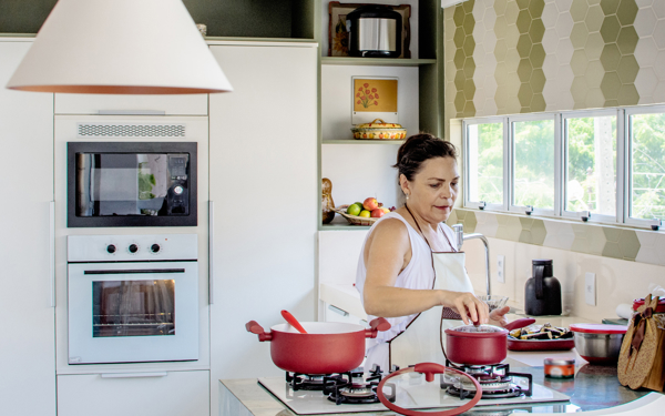 Vrouw bereidt maaltijd op haar gasfornuis