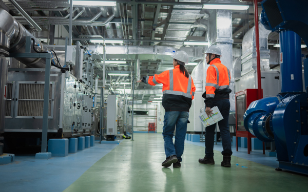 Werknemers lopen door een industrieel installatiesysteem