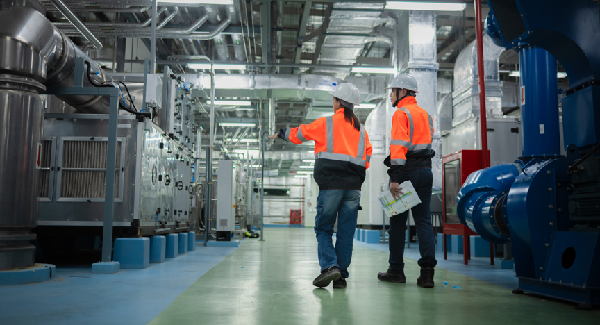 Werknemers lopen door een industrieel installatiesysteem