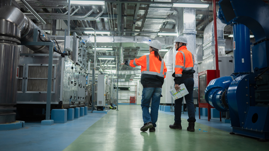 Werknemers lopen door een industrieel installatiesysteem