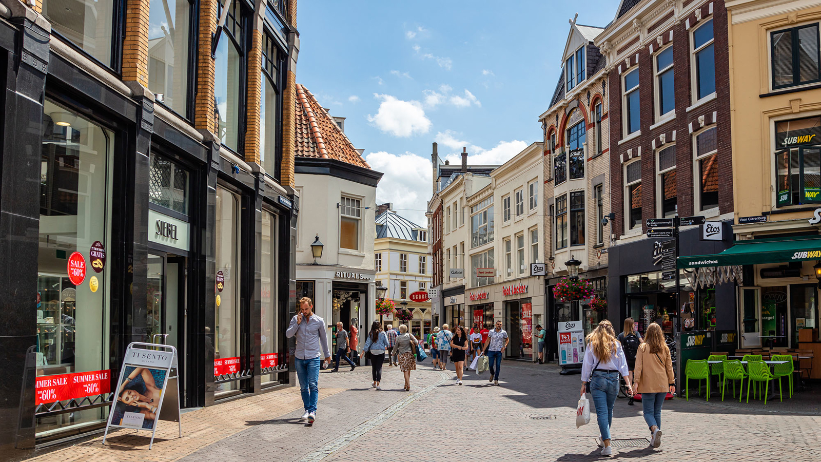 Mensen in een winkelstraat bij mooi weer