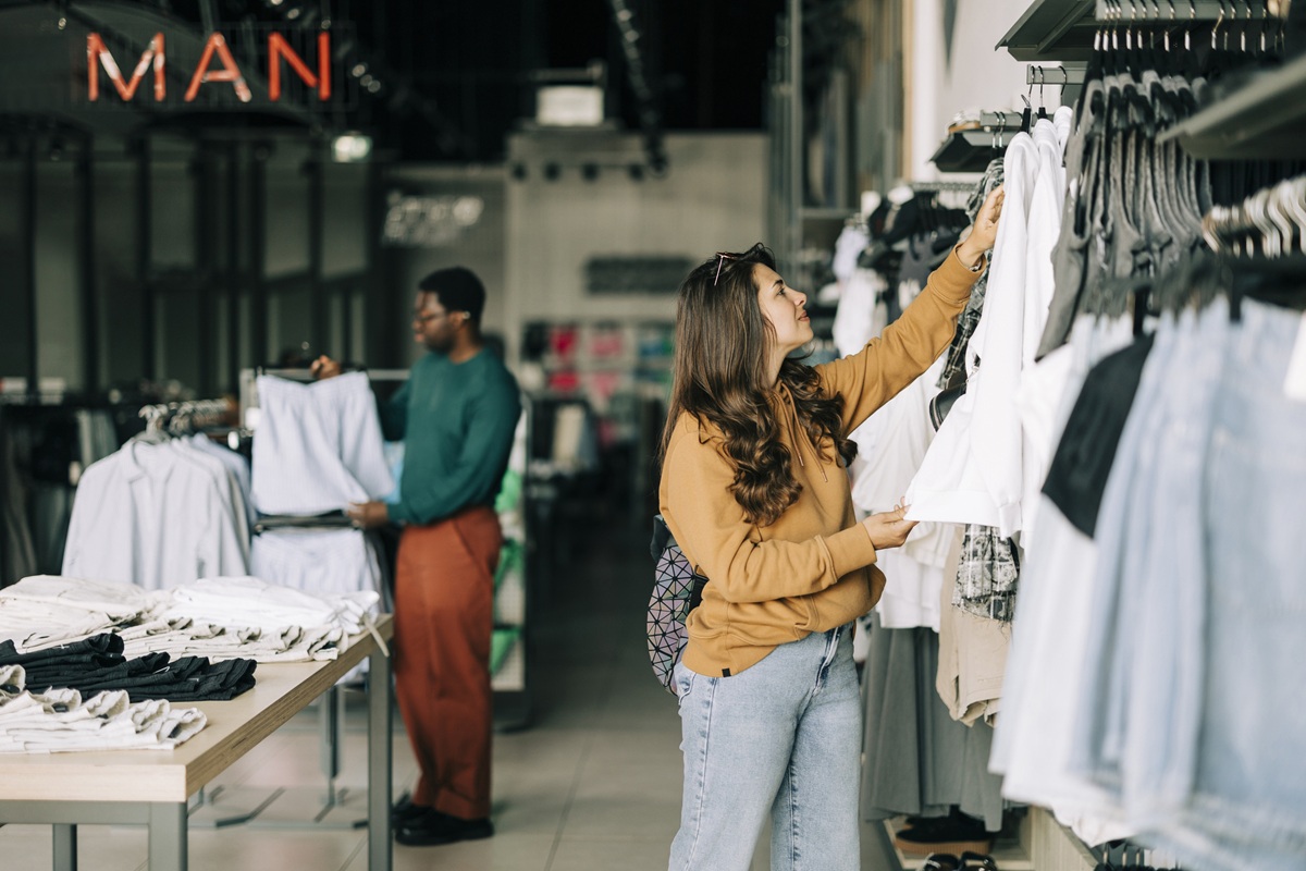 Vrouw en man bekijken kleding in kledingwinkel