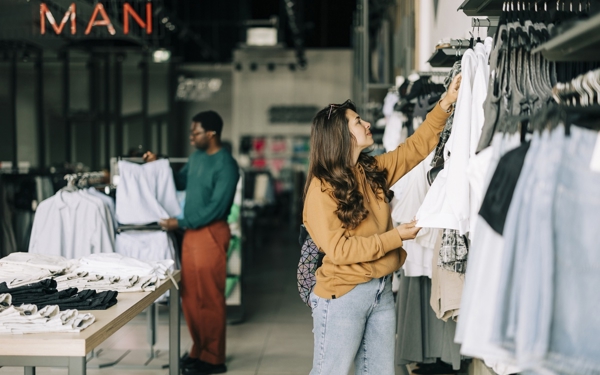 Vrouw en man bekijken kleding in kledingwinkel