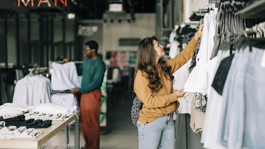 Vrouw en man bekijken kleding in kledingwinkel
