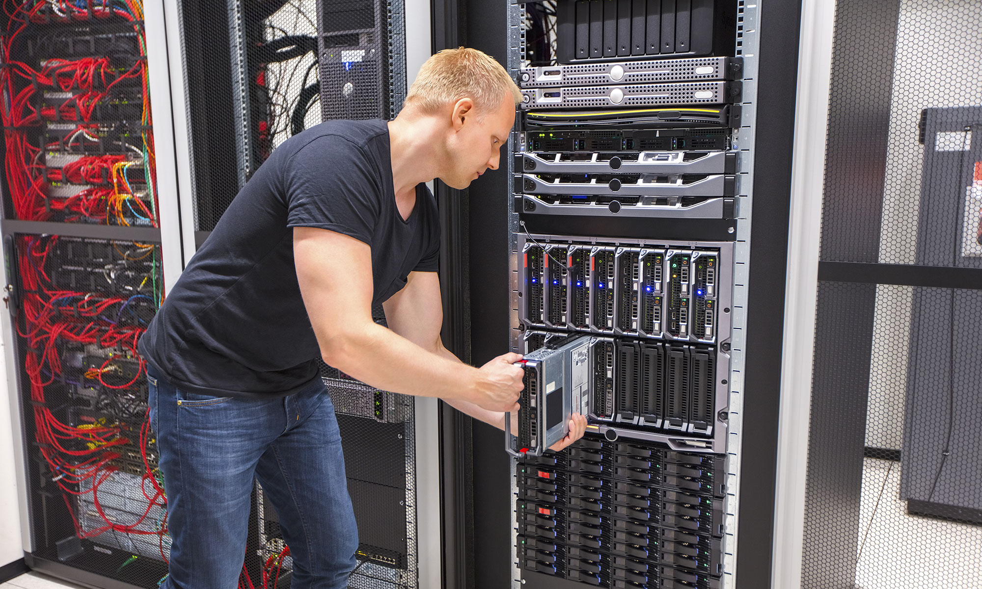 Man die een lade uit een grote computerkast haalt