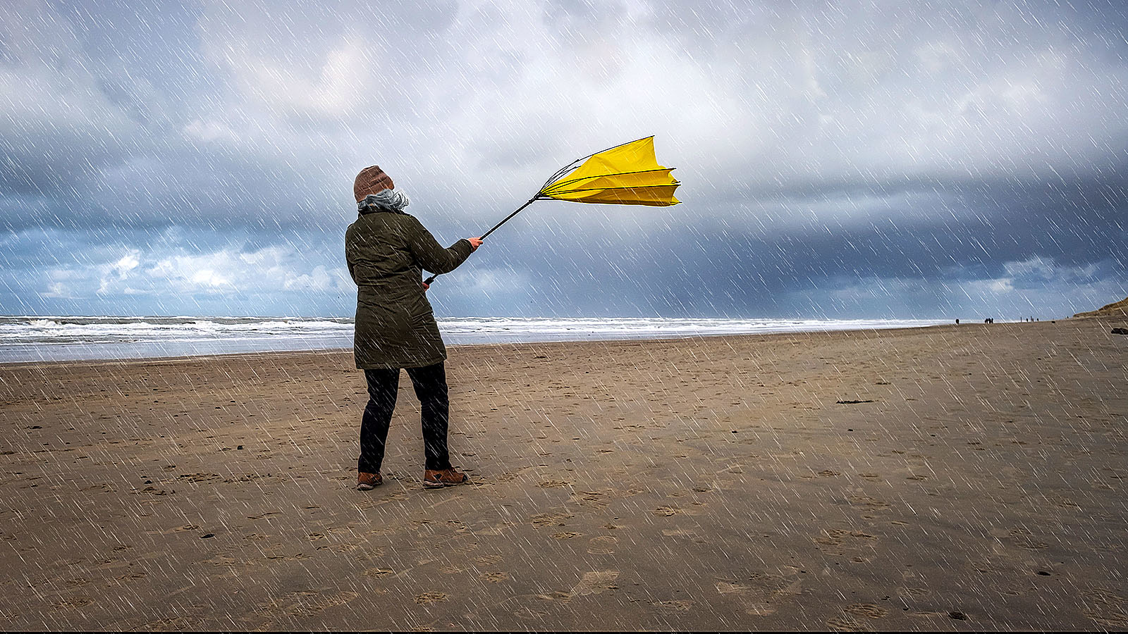 Persoon op strand met wind