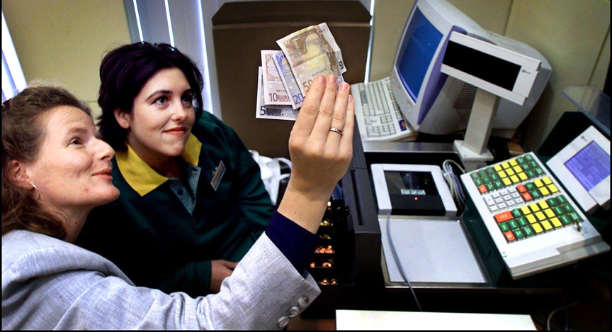 Een instructrice (L) leert een cassiere in 2001 de watermerken van de nieuwe eurobiljetten te herkennen.