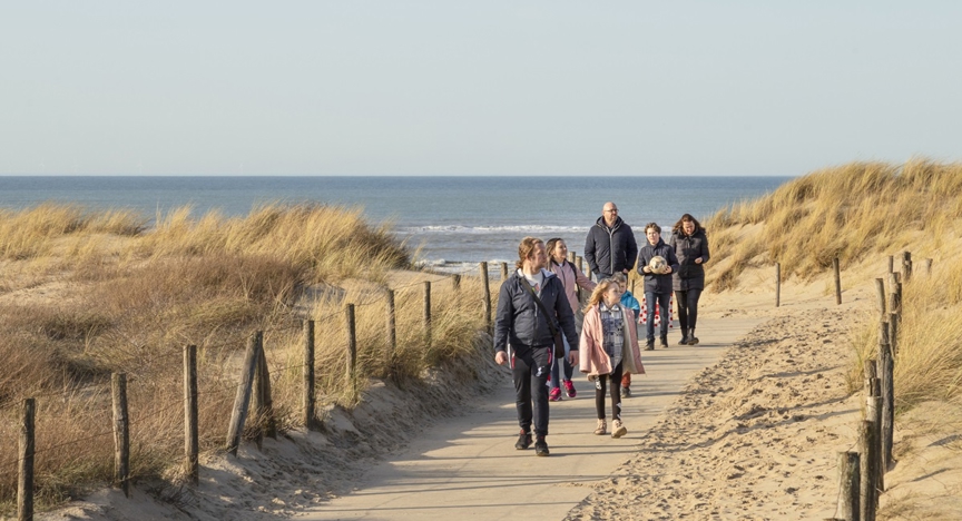 Nederlands gezin wandelt door de duinen.