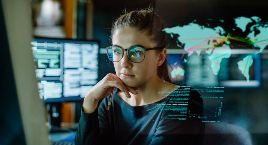 Een vrouw zit achter de computer en monitort transacties