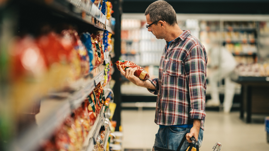 Man leest label van product in een supermarkt