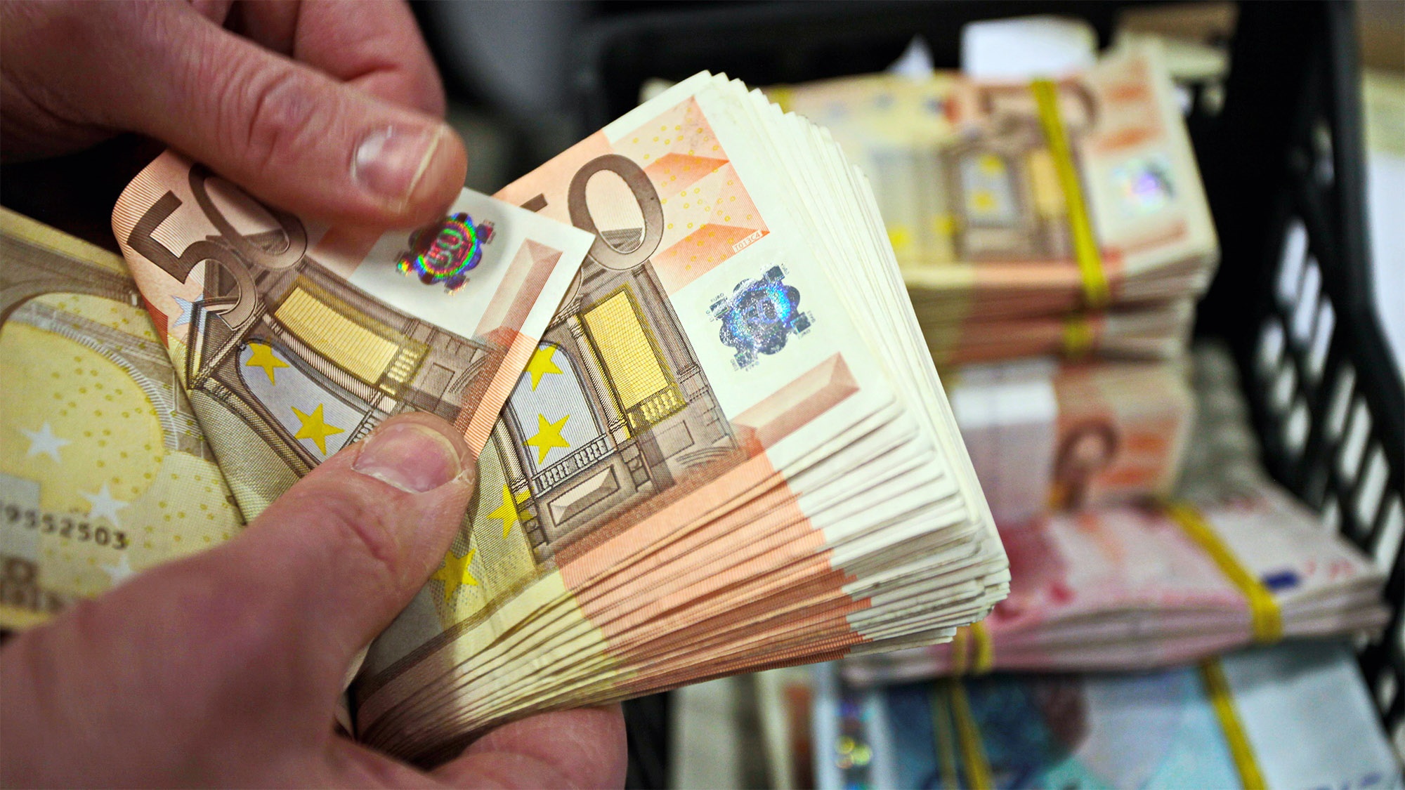 Iemand die een stapel van 50 euro biljetten vasthoudt