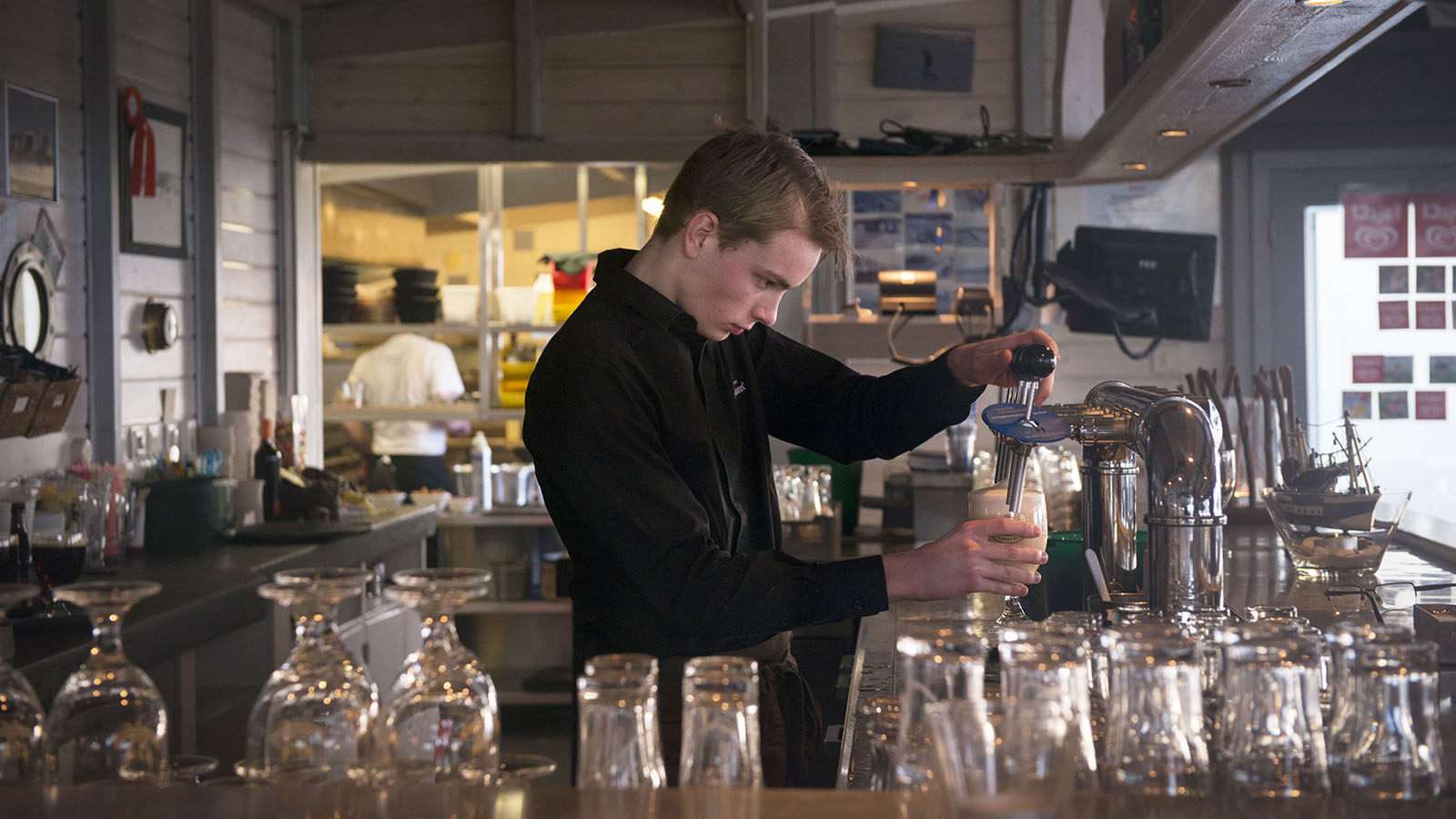 Jongen achter bar in horecagelegenheid