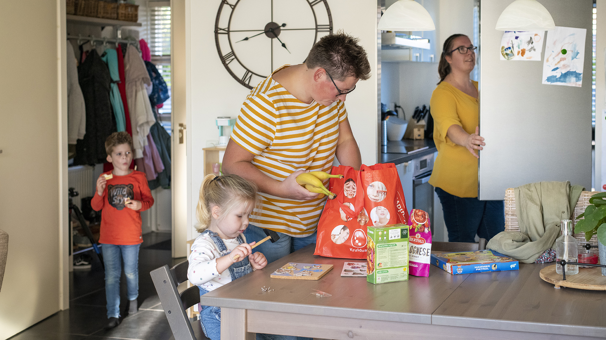 Thuis bij een gezin boodschappen uitpakken in de keuken. 