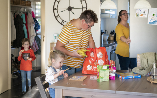 Thuis bij een gezin boodschappen uitpakken in de keuken. 