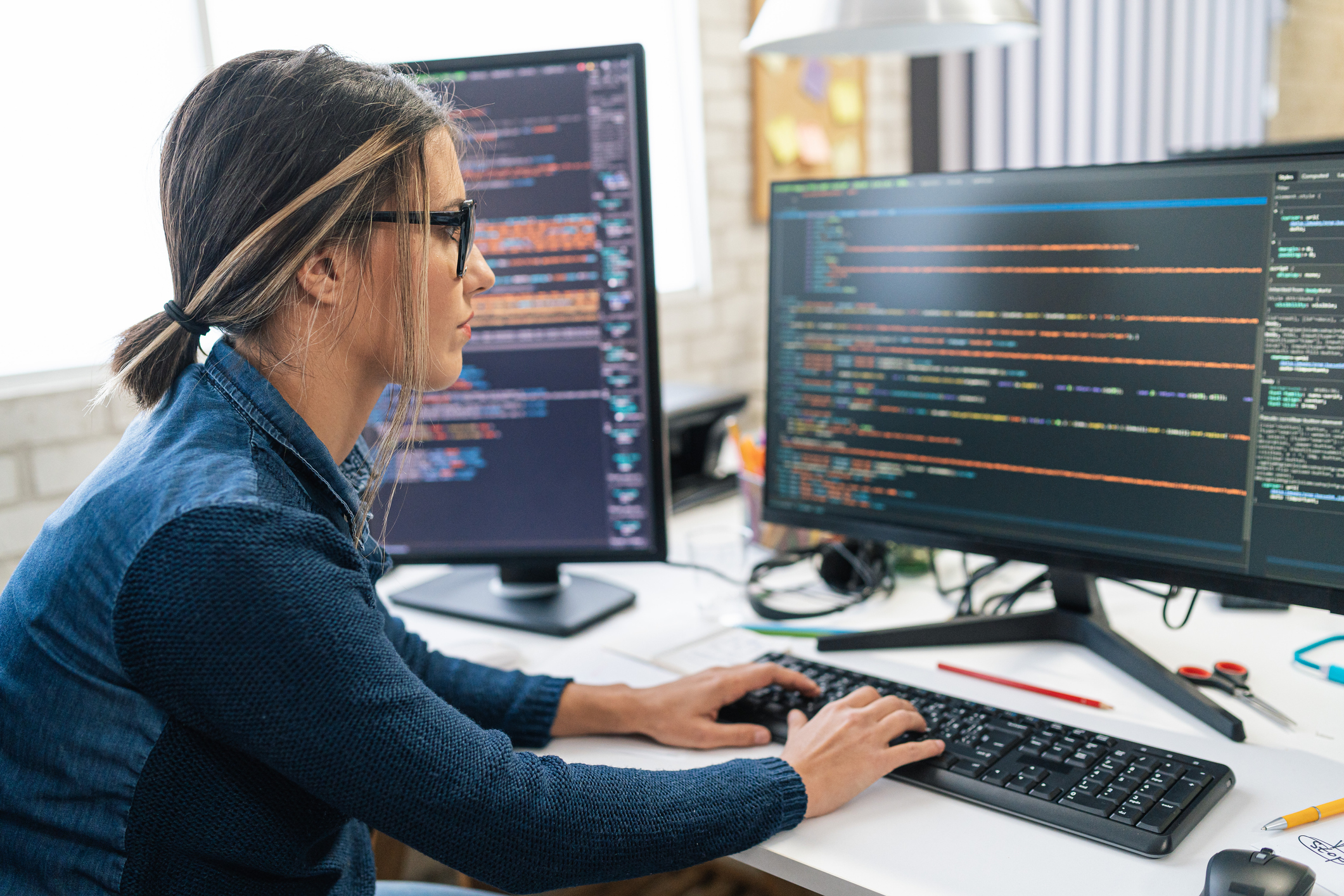 Medewerker bij een verzekeringsmaatschappij bekijkt code op een computer beeldscherm.