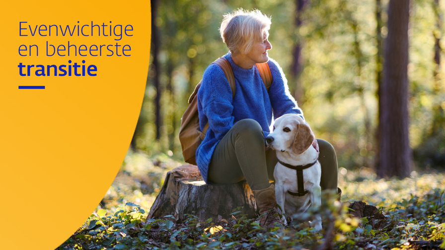 Vrouw zit op een boomstam in het bos met een hond naast haar.